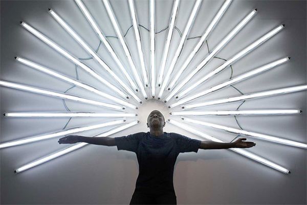 a man standing in front of a large light fixture