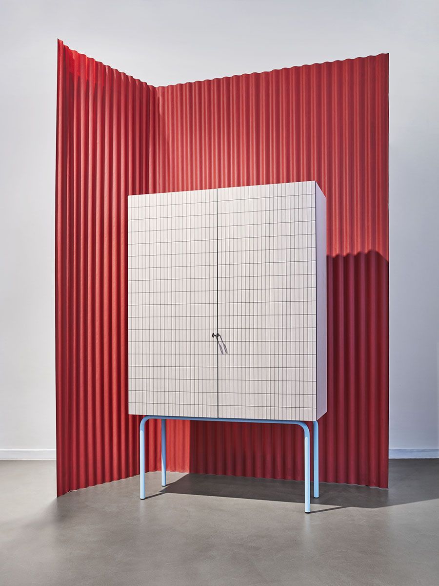 a white cabinet sitting in front of a red wall