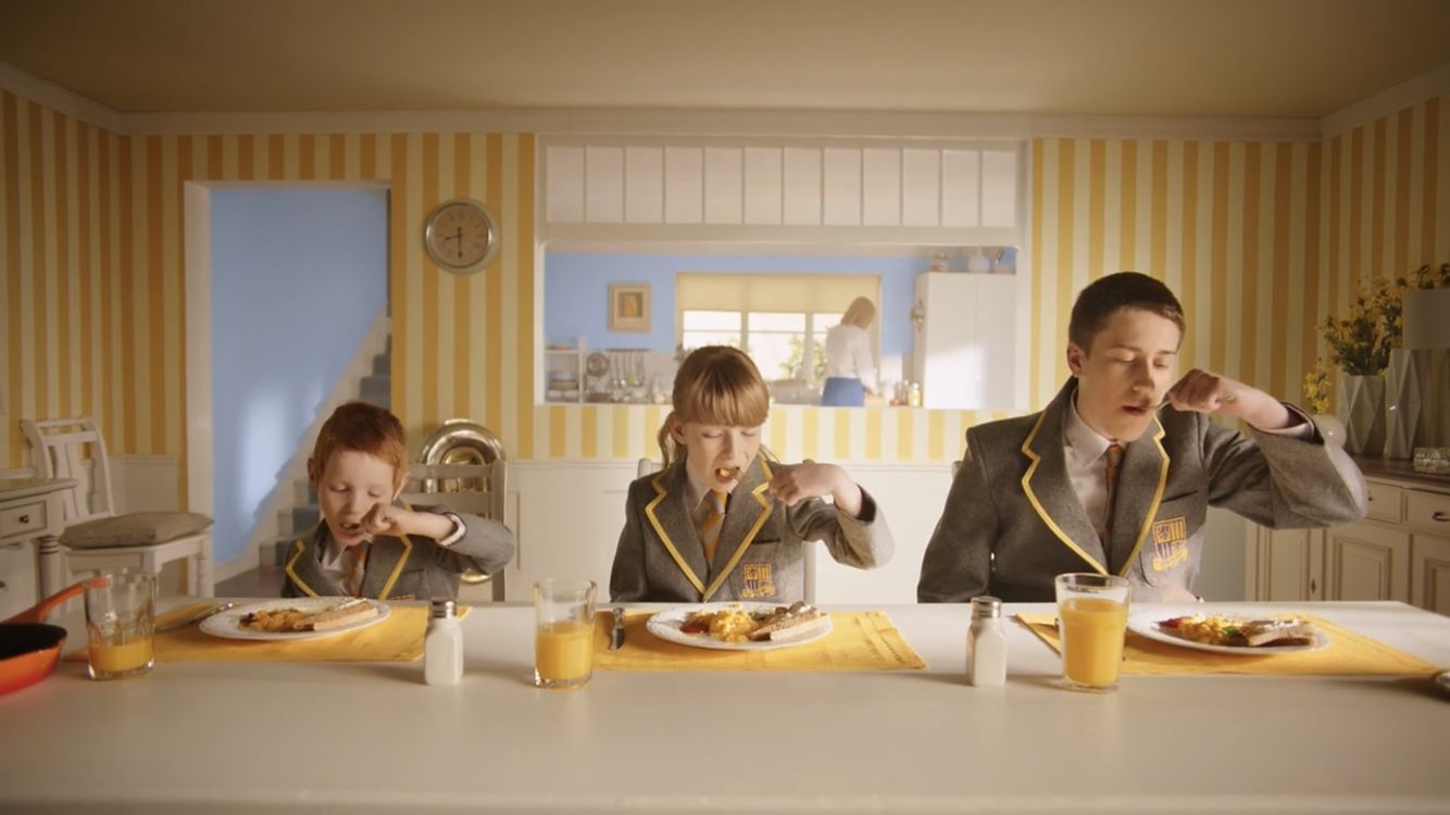 a man and two children sitting at a table eating food