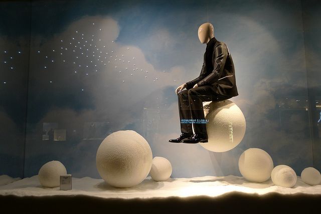 a mannequin sitting on top of a ball in a room