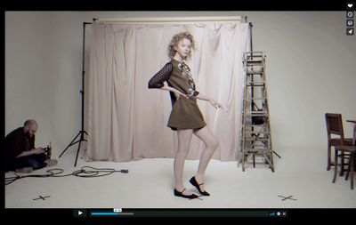 a woman standing in front of a camera in a room