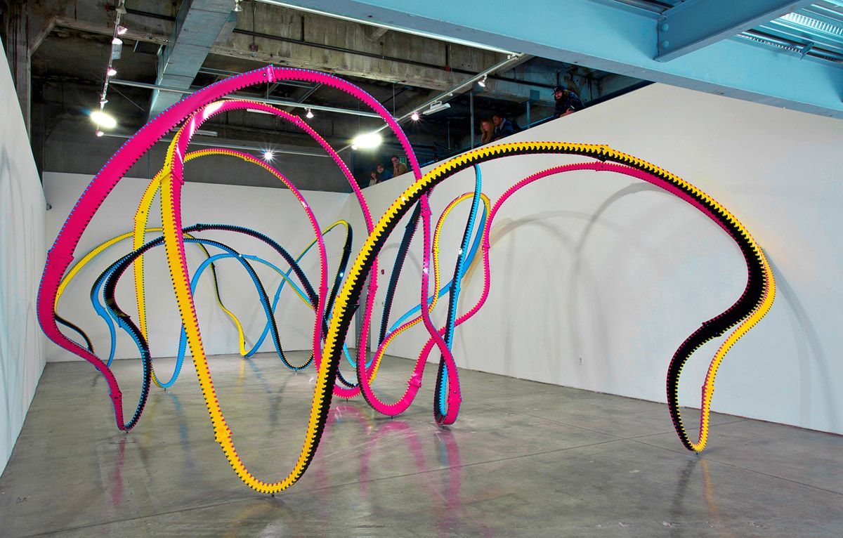 a group of colorful hoses sitting on top of a cement floor