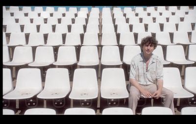 a man sitting in a row of white chairs