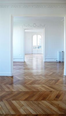 an empty room with wooden floors and white walls