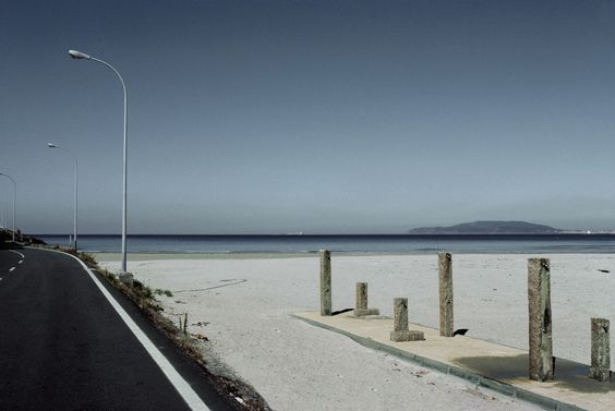 a deserted beach with a long road going through it