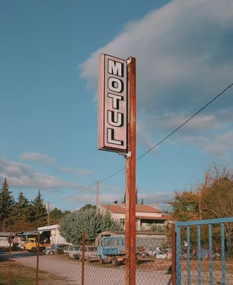 a motel sign sitting on the side of a road