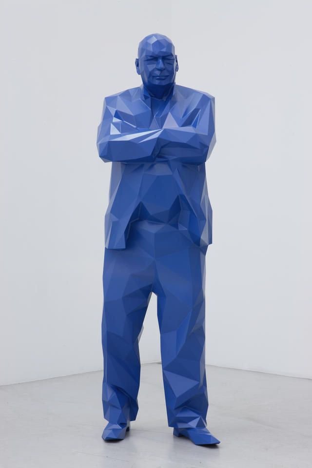 a blue sculpture of a man with his arms crossed