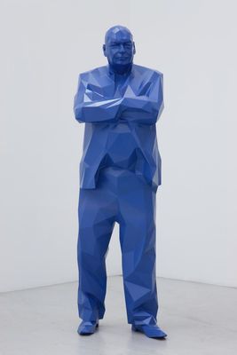 a blue sculpture of a man with his arms crossed