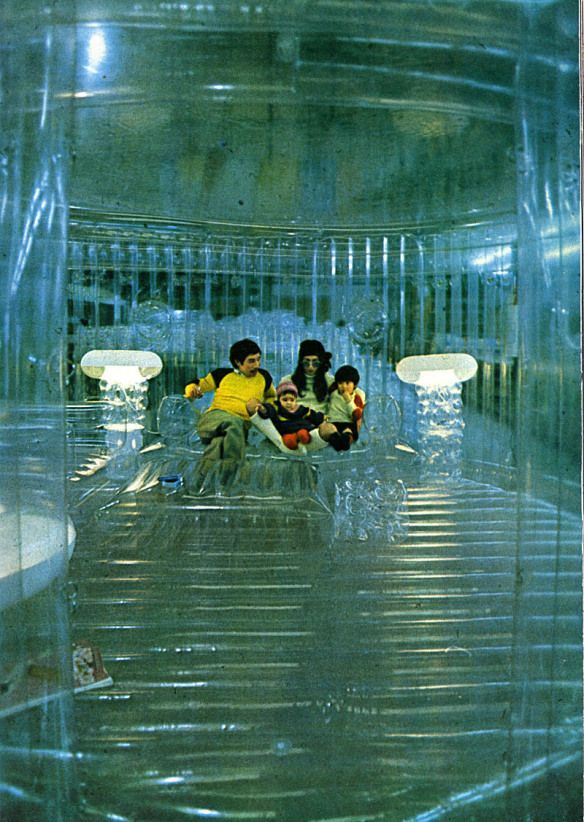 a group of people sitting in a room filled with plastic