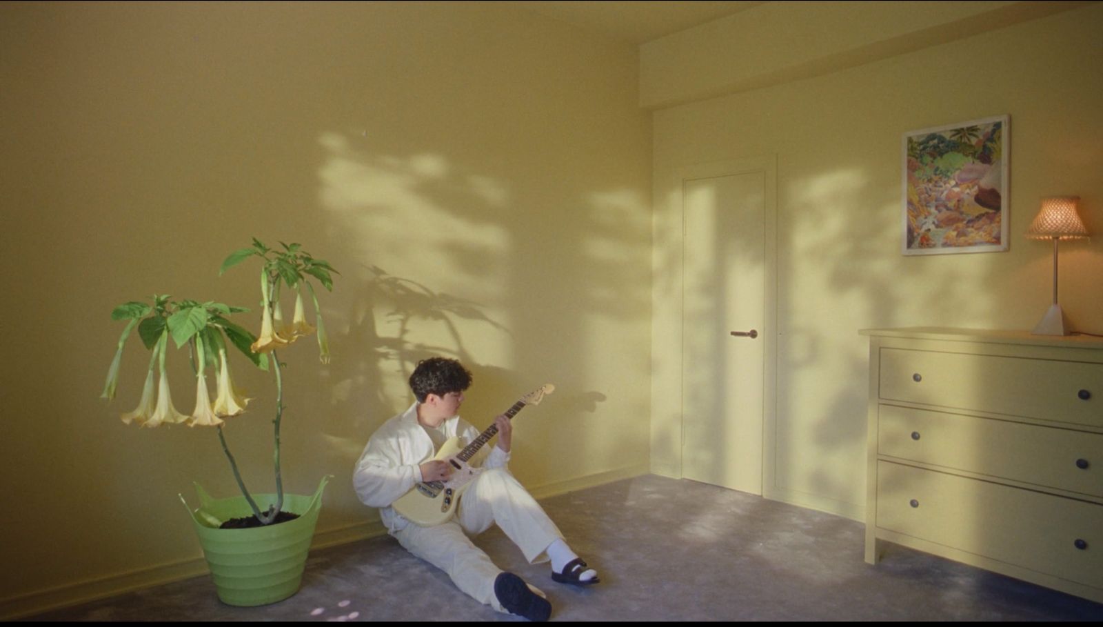 a man sitting on the floor playing a guitar