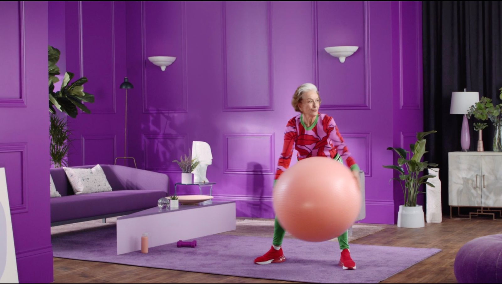 a woman in a room with purple walls and a pink balloon