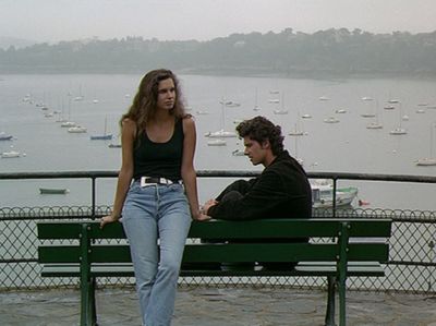 a woman sitting on a bench next to a man