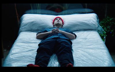 a person laying on a bed with a red headband