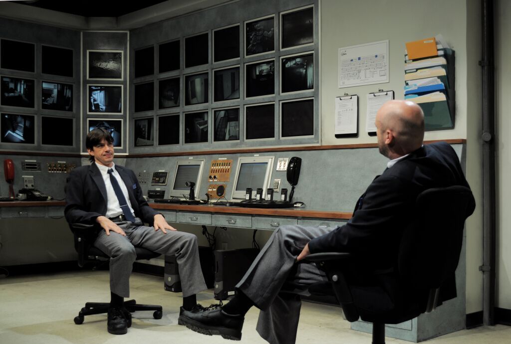 a couple of men sitting in chairs in a room