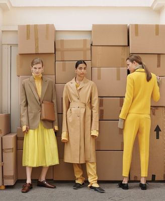 three people standing in front of cardboard boxes