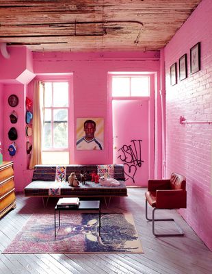 a living room with pink walls and furniture