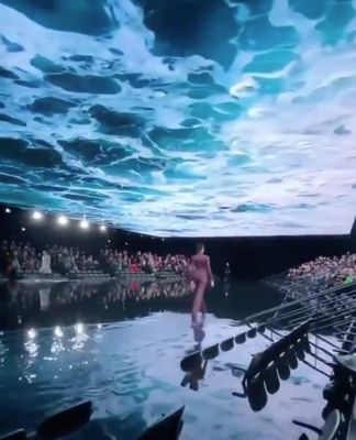 a man walking across a body of water in front of a crowd