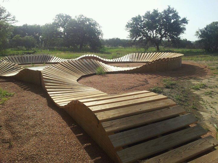 a wooden bench sitting on top of a dirt field