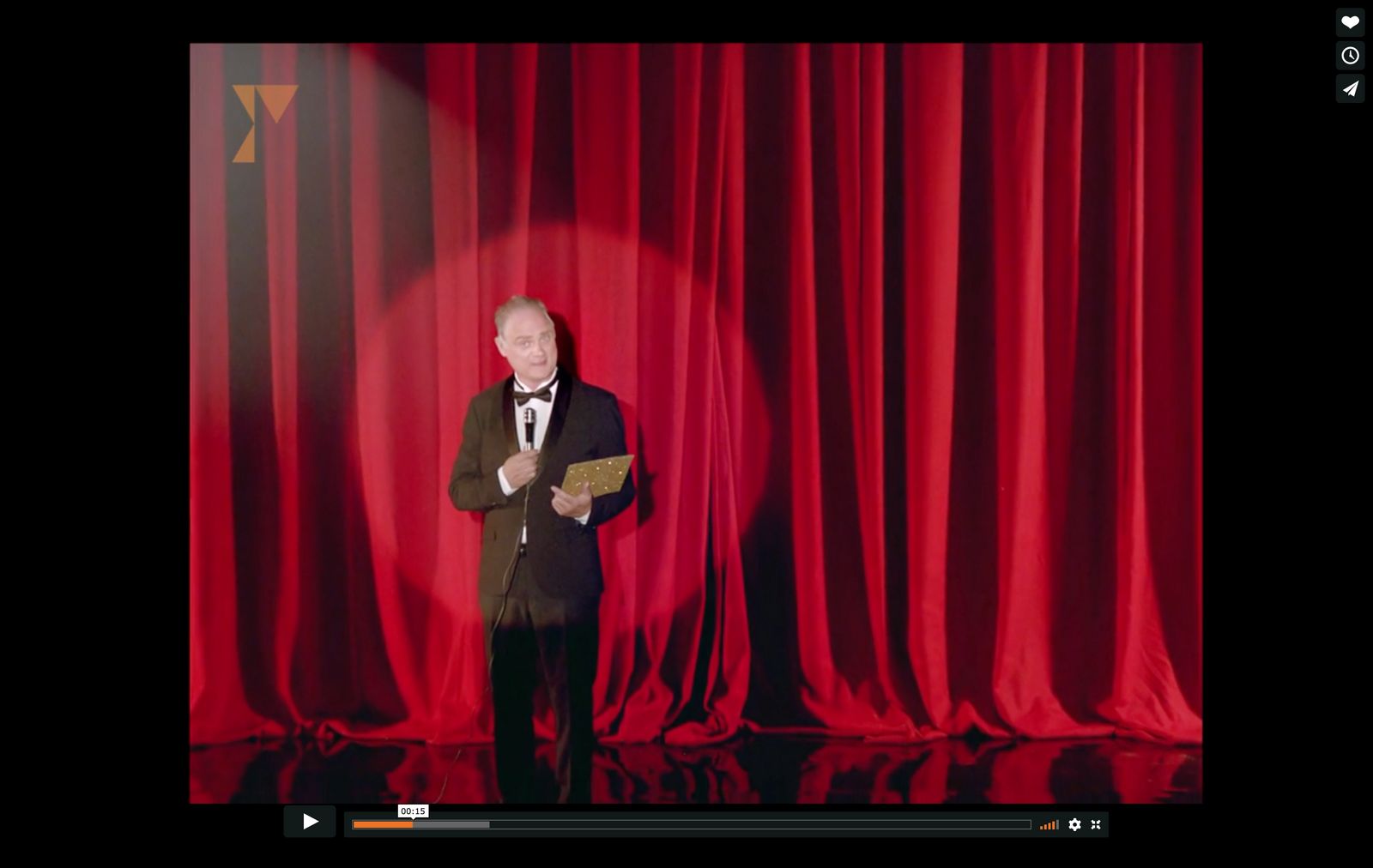 a man standing in front of a red curtain