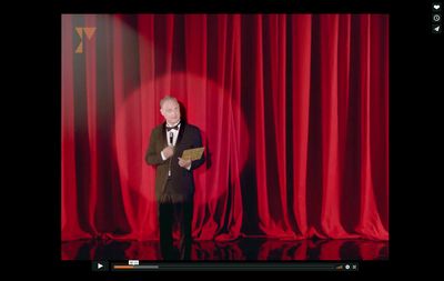 a man standing in front of a red curtain