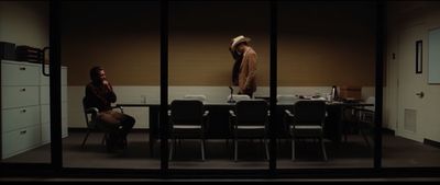 two people sitting at a table in a room