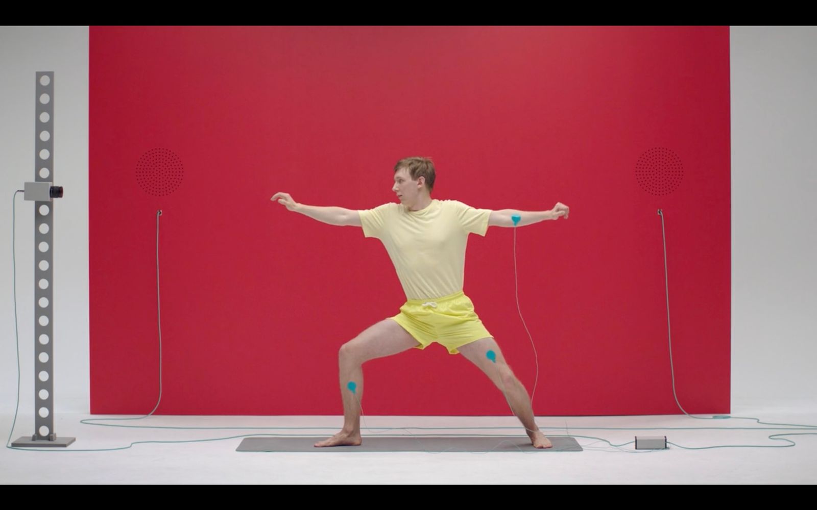 a man in a yellow shirt is doing a yoga pose