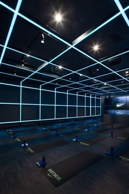 a dark room with blue lights and yoga mats