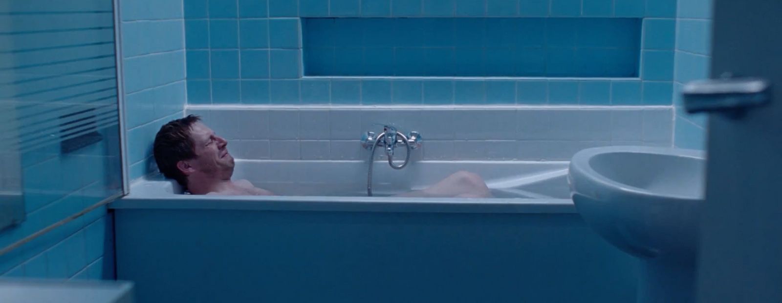 a man sitting in a bathtub in a bathroom