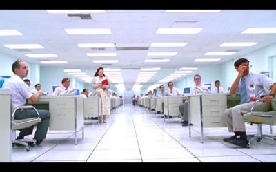 a group of people sitting at desks in a room