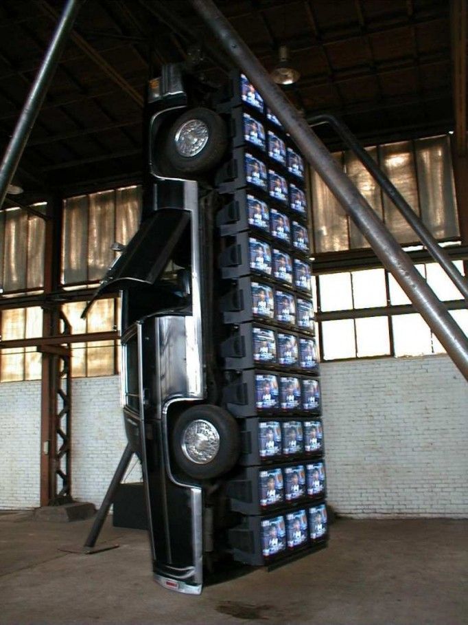 a large stack of televisions sitting inside of a building