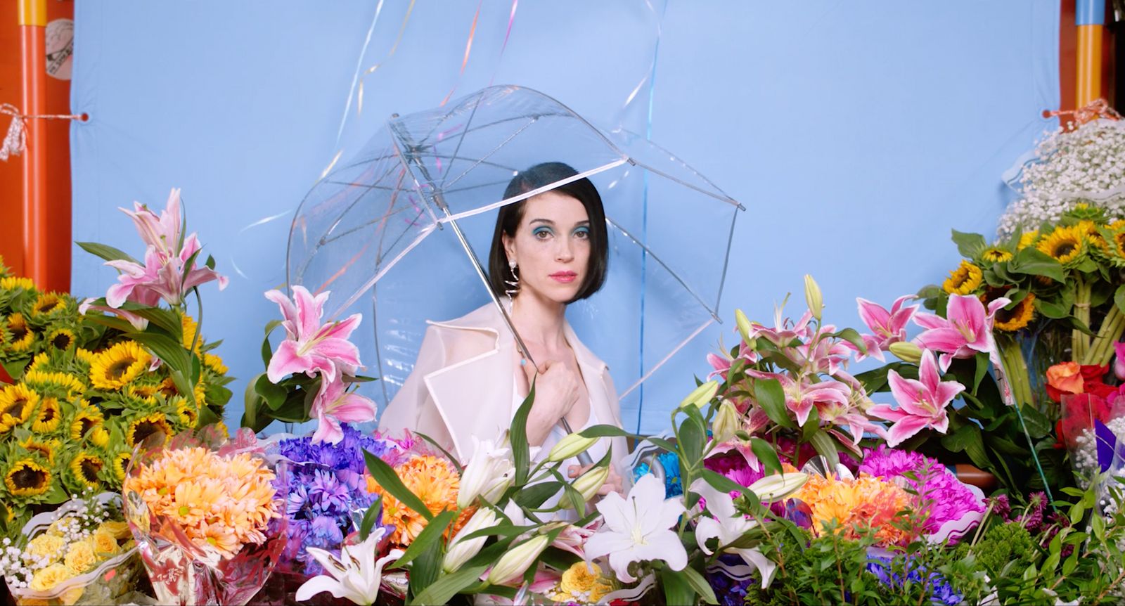 a woman holding an umbrella over her head surrounded by flowers