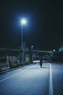 a person walking down a street at night