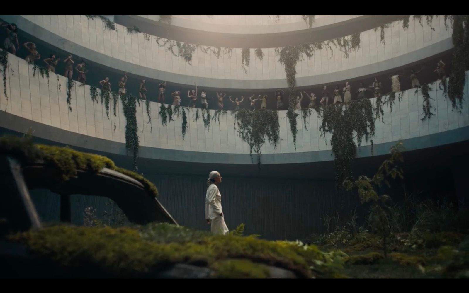 a person standing in a room with moss growing on the walls