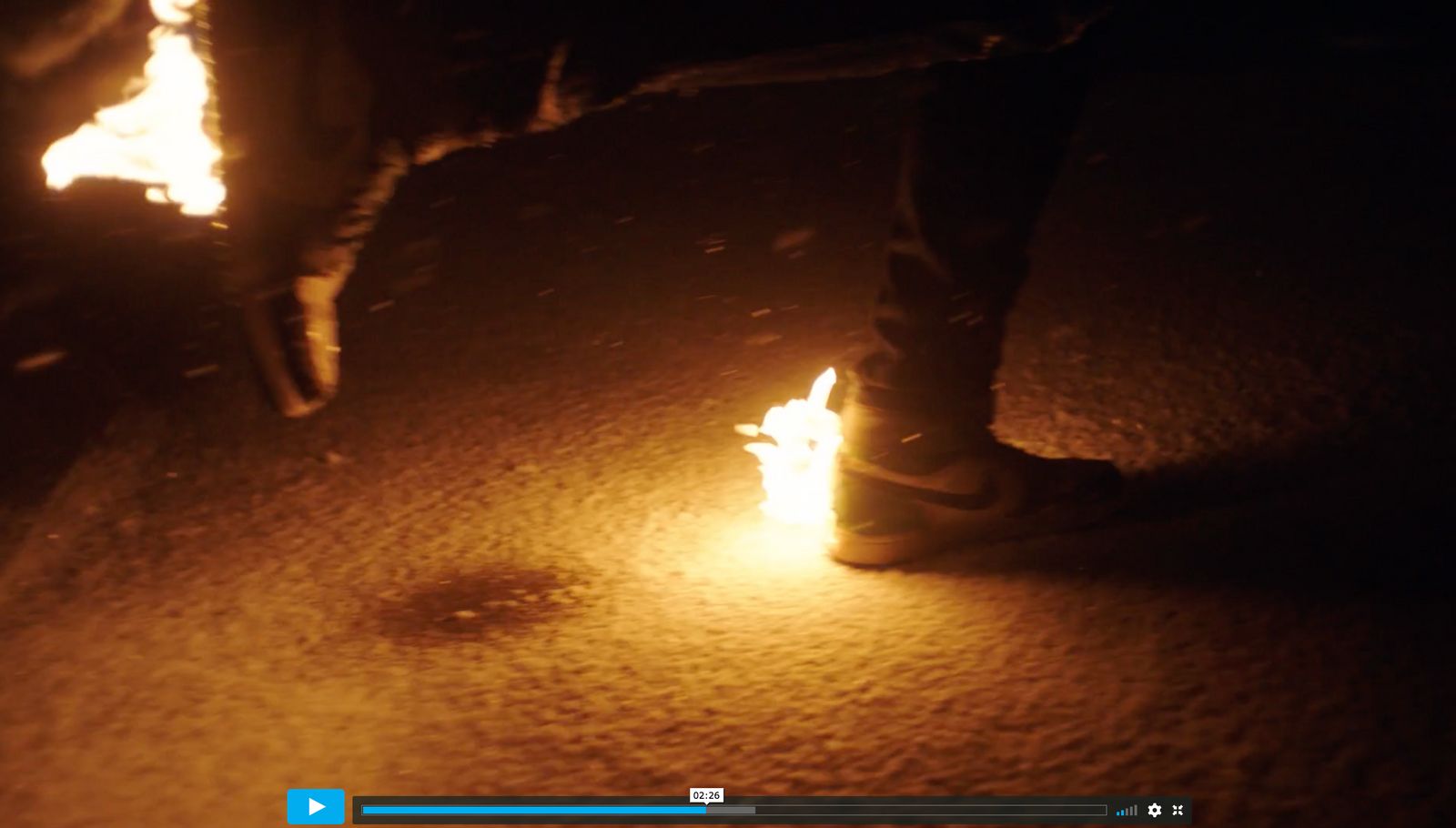 a person standing next to a fire in the dark