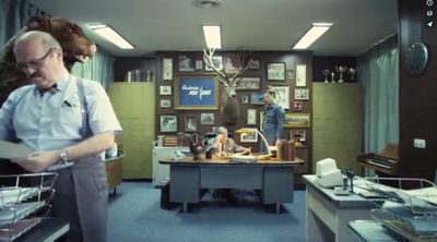 a man standing in a room filled with lots of items