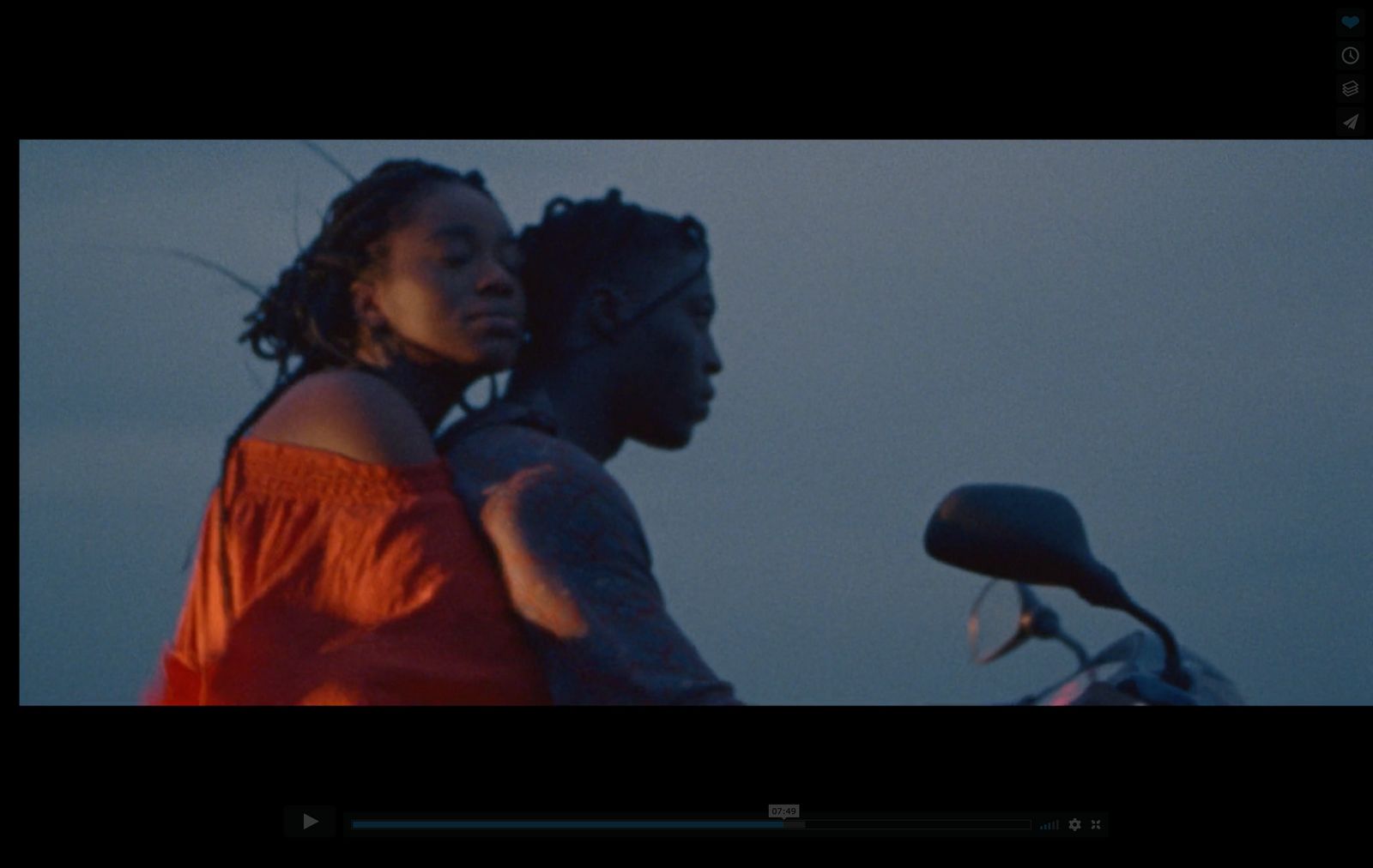 a woman standing next to a man on a motorcycle