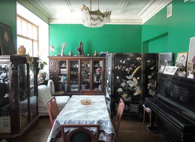 a room with green walls and a table and chairs