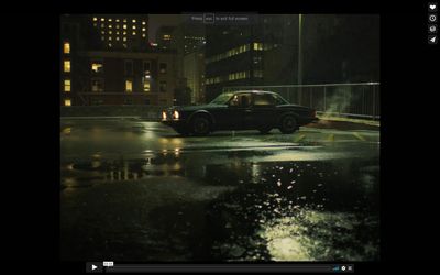 a car driving down a rain soaked street at night