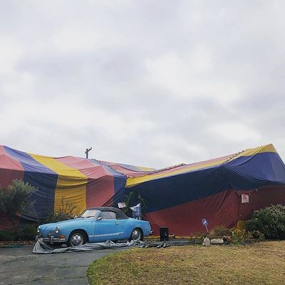 a car is parked in front of a large tent