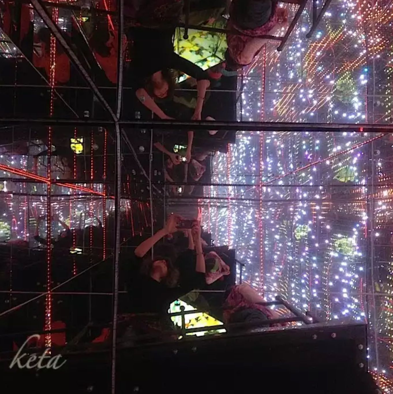 a group of people standing in front of a display of lights