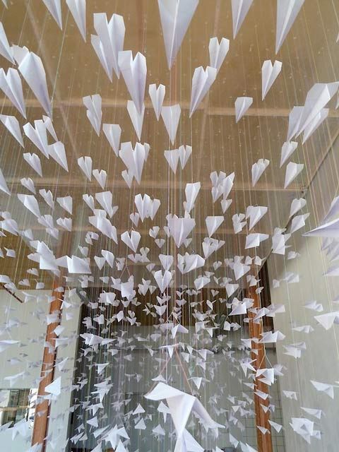 a room filled with lots of white paper flying through the air