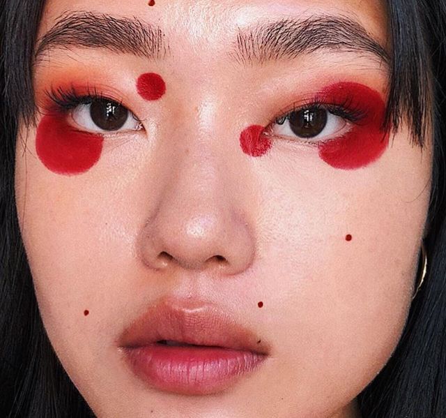 a close up of a person with red makeup