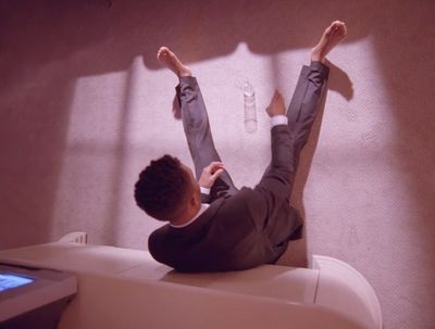 a man laying on top of a white table