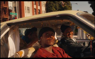 a group of men riding in the back of a car