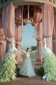 a woman in a wedding dress standing in front of a gazebo