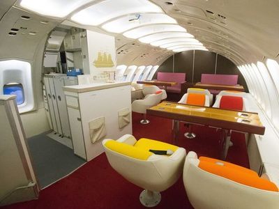 the inside of an airplane with several seats and tables