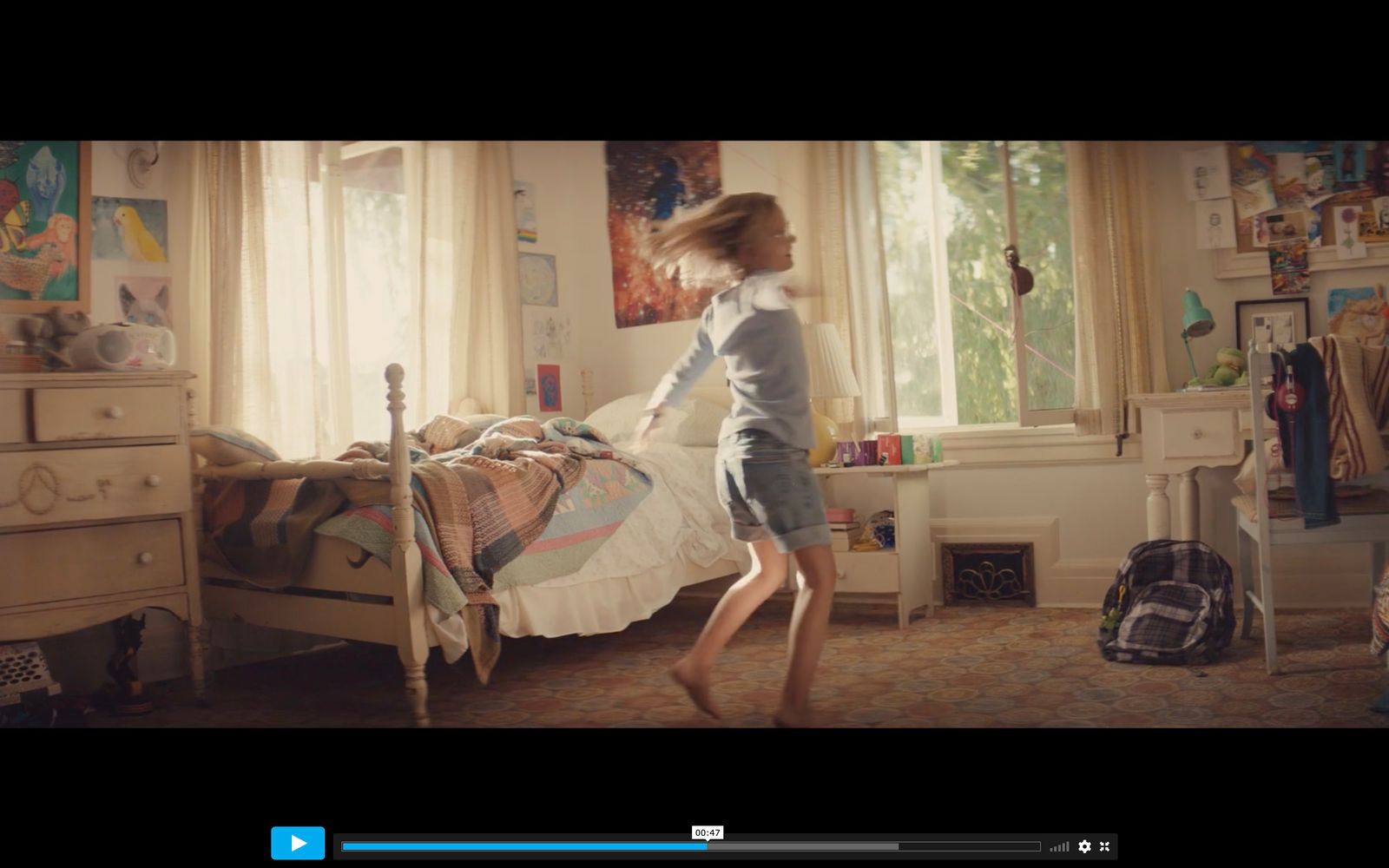 a girl jumping in the air in a bedroom