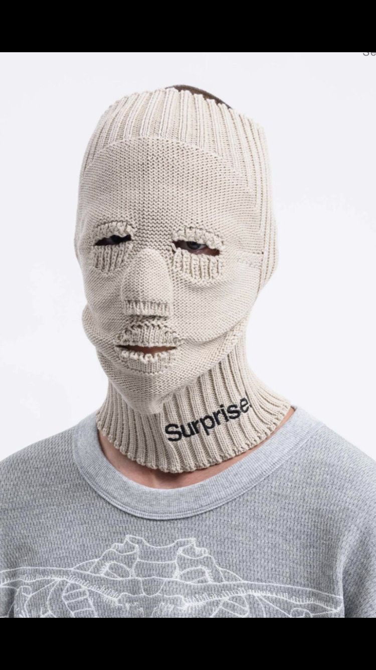 a man wearing a white mask with the word surprise written on it