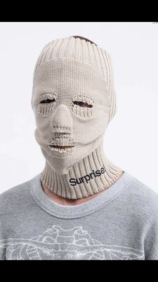 a man wearing a white mask with the word surprise written on it