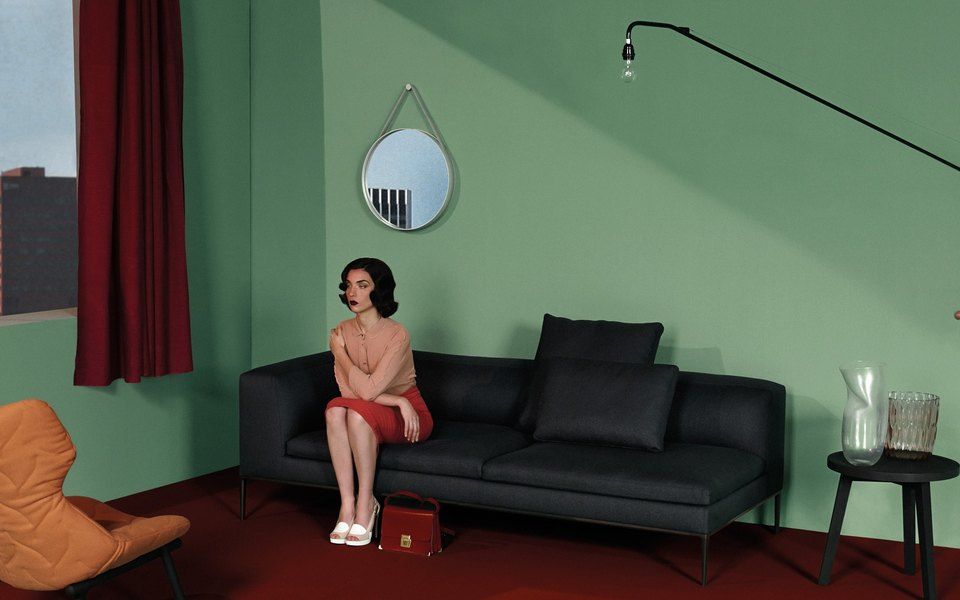 a woman sitting on a couch in a green room